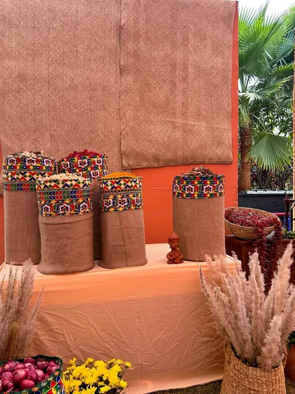 A wider view of the decorated burlap sacks, set against a textured backdrop, forming part of the vibrant and interactive decor for the Haldi ceremony.