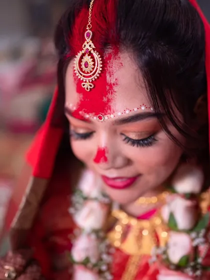 A close-up shot capturing the 'Sindoor Daan', a pivotal and emotional moment in a Bengali wedding ceremony.