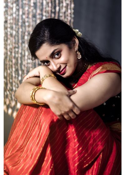 A warm and intimate seated portrait. The model's gentle smile and relaxed posture create a feeling of comfort and joy, perfect for festive-themed shoots.