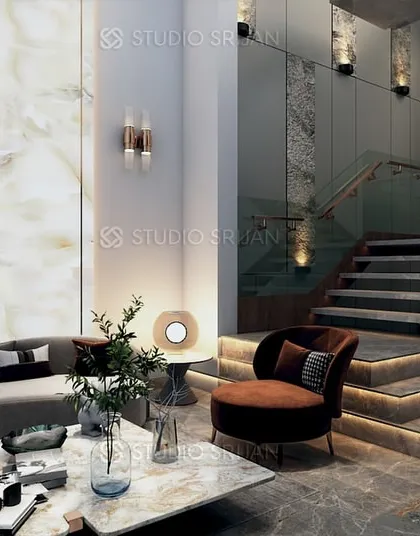The entrance lobby of a Pitampura residence, featuring a grand staircase with integrated lighting and a stunning backlit onyx wall that creates a warm, welcoming glow.