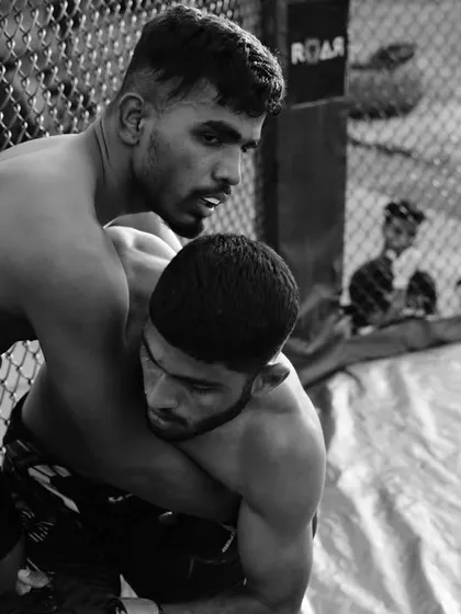 This black and white shot captures the raw intensity of a cage fight. The struggle for control, the focus in the fighter's eyes, this is the essence of mixed martial arts.
