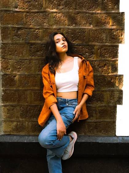 A more serious, fashion-oriented pose against the same wall, showing the versatility of a simple urban location.