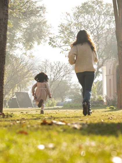 A mother and daughter running through a sunlit park. These are the unposed, story-filled moments that I love to capture, showing the energy and connection of your family.