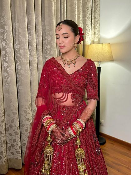 A full-length view of Simran's elegant bridal look. The sleek bun with a red rose adds a touch of classic romance.