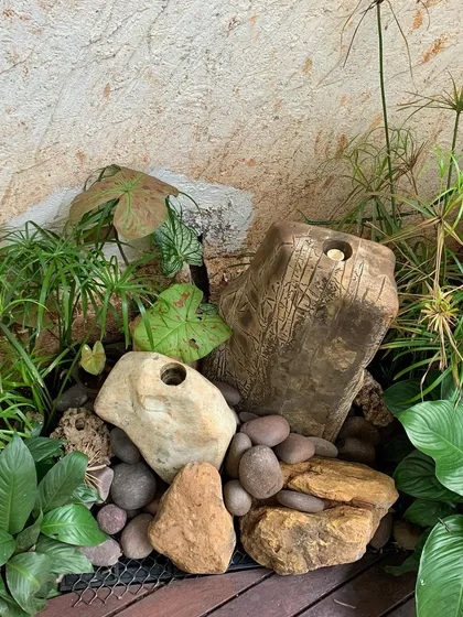 A closer look at a fountain arrangement where I've used a variety of river stones and pebbles to hide the base and create a natural-looking dry creek bed effect. The details are just as important as the main feature.