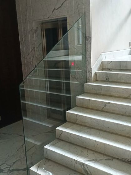 A frameless glass railing for a marble staircase. This minimalist design provides safety without obstructing the view, making the space feel larger and more open.