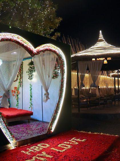 A full view of our signature heart-shaped cabana, decorated for a romantic evening. The path of flower petals and the soft lighting create a truly magical entrance for your special night.