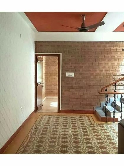 An interior view showing the combination of patterned floor tiles and exposed brick walls near a staircase.