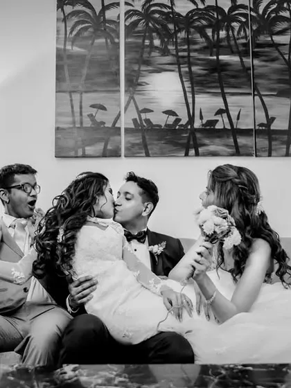 The newlyweds share a kiss, surrounded by the chaotic joy of their friends. This candid shot is full of life, laughter, and the fun of celebrating with your favorite people.