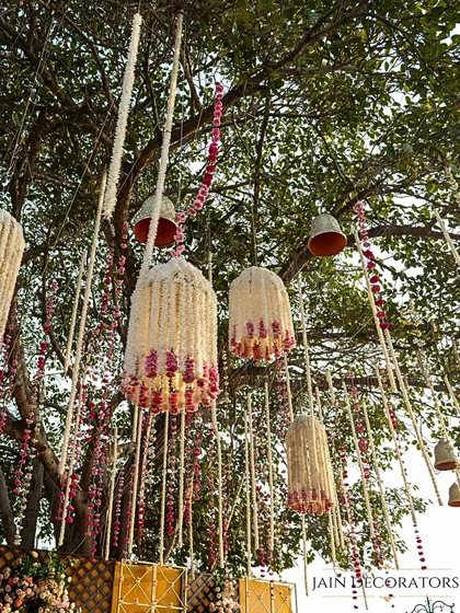 A whimsical detail hanging from the trees. These beautiful floral chandeliers, made from jasmine and roses, add a touch of magic and fragrance to the outdoor setting.