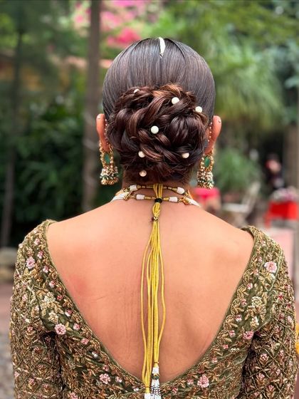 The detail in this pearl-studded messy bun shows how texture can add depth to a bridal hairstyle.