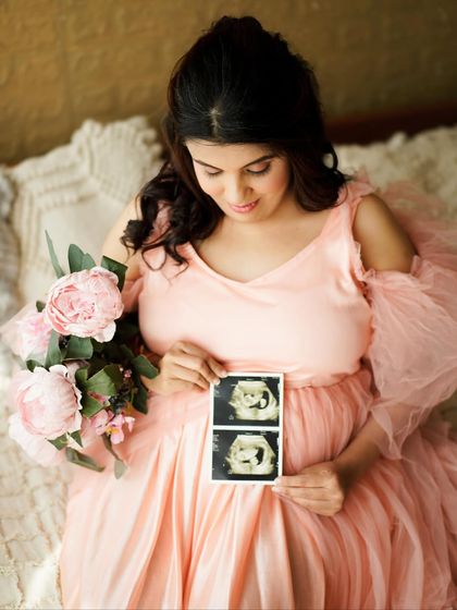 A beautiful solo portrait of the mother-to-be holding her sonogram picture, a quiet and personal way to celebrate her baby.