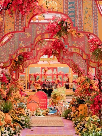 For the couple that loves color and artistry, this haldi entrance is a masterpiece. The layered, hand-painted arches and vibrant floral arrangements create an immersive experience that's both traditional and incredibly modern.