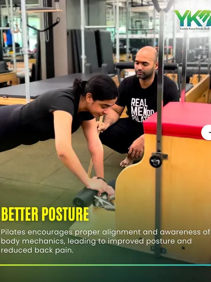 Proper alignment is key. Here, a trainer guides a client on the Wunda chair, ensuring she maintains good posture to reduce back pain and maximize the exercise's benefits.