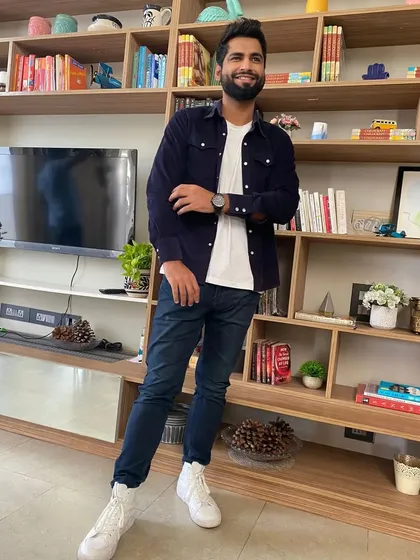 The full look, including crisp white sneakers, completes the modern and clean aesthetic for Harsh Gujral's shoot. It's all about looking put-together without being overdone.