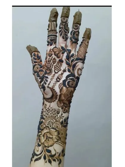 This design incorporates elements like a crescent moon and lanterns, telling a story within the traditional bridal mehndi.
