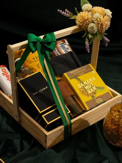 Another angle of our Rakshabandhan hamper for a brother, showcasing the elegant arrangement of perfume, snacks, and a coffee tumbler in a reusable wooden basket.