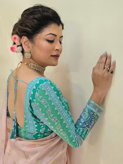 A profile shot showing the detailed embroidery on the sleeve of the blouse and the neatness of the hairstyle.