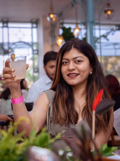 A guest raises her glass, toasting to a wonderful evening filled with delicious food and great company.