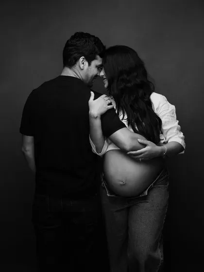 An intimate moment of connection, captured in soft black and white. Their casual attire makes this portrait feel authentic and deeply personal.