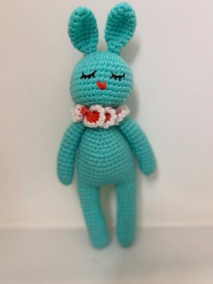 A sleepy-eyed turquoise bunny with a cute heart-patterned collar.