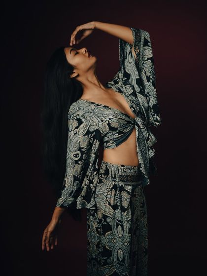 A full-body shot with a graceful, dance-like pose. The lighting is soft and even.