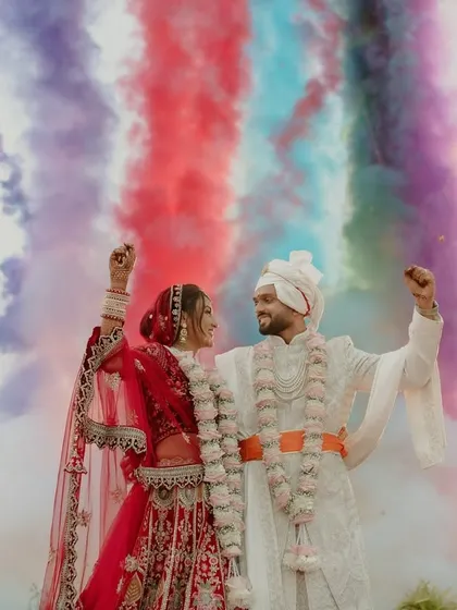 A sky painted with the colors of love. This vibrant smoke effect created a stunning backdrop for the couple's Varmala, a unique touch that made their moment stand out.