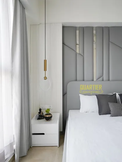 A close-up showing the interplay of light and texture by the window in the guest bedroom. The sheer curtains diffuse the natural light, creating a soft and calming ambiance.