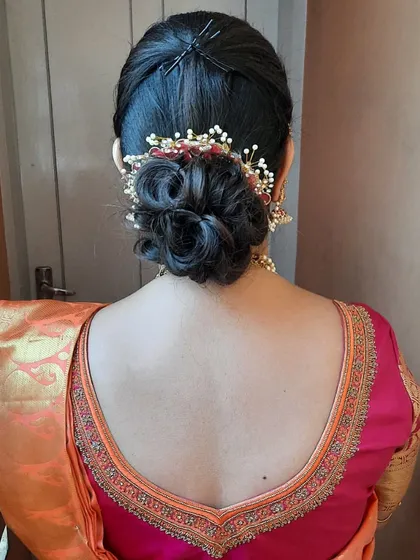 A classic messy bun, elegantly styled with a decorative hair pin. This versatile updo is perfect for any occasion, from parties to traditional ceremonies.