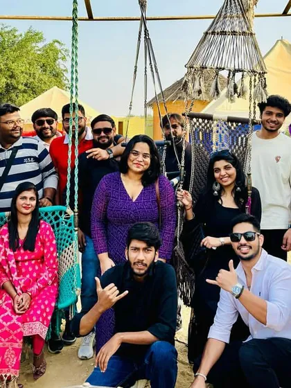 A fun group photo at a desert camp in Jaisalmer. The swings and hammocks add to the relaxed vibe.