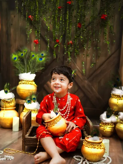 A heavenly smile from our little Krishna. The golden matkis and peacock feathers create a rich and festive atmosphere.