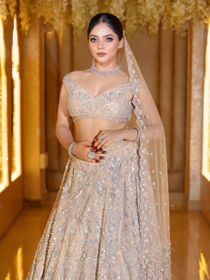 A three-quarter view of this elegant reception look. The soft lighting highlights the shimmer on the lehenga and the glow on her skin.