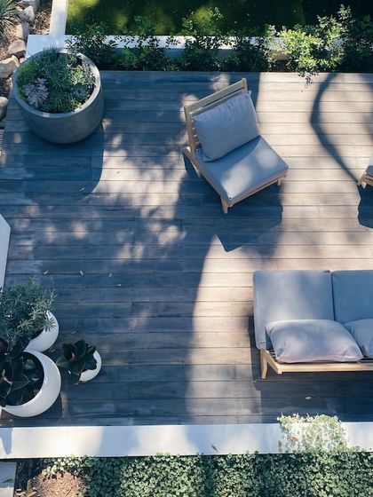 An overhead view of a perfectly balanced deck design. The minimalist furniture, simple color palette, and carefully placed planters create a space that is both stylish and serene.