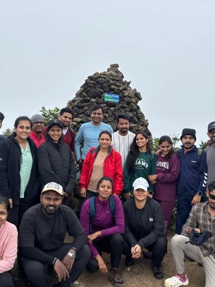 The full group smiling for a photo, celebrating their progress on the demanding Kumaraparvatha trek.