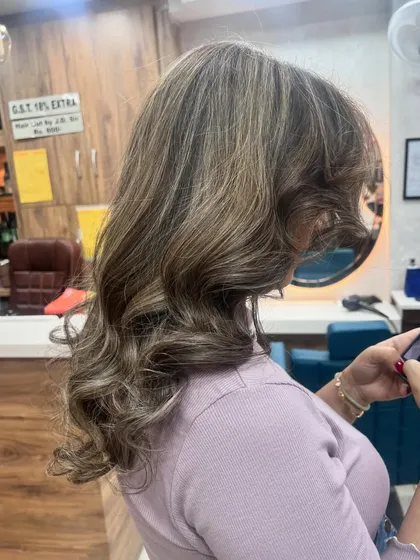 A side view of this expertly styled hair, showing how the curls and highlights work together to create a stunning profile.