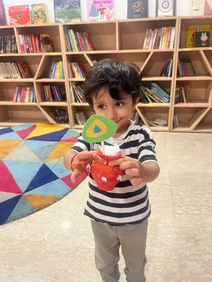A sweet moment from our Janmashtami celebration. This child is holding up a 'dahi handi' craft he made, connecting a fun activity with the story of Lord Krishna.