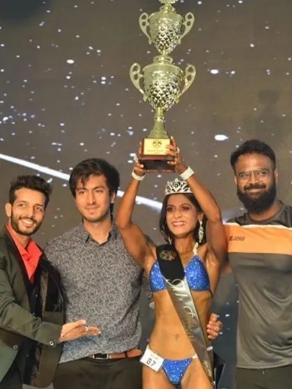 Celebrating my ICN Overall Champion win with my coach and the event organizers. This victory was a team effort.