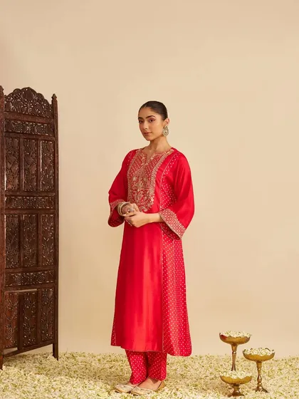 A full-length view of the red kurta set, showing its graceful A-line silhouette and matching pants, perfect for comfortable yet stylish festive wear.