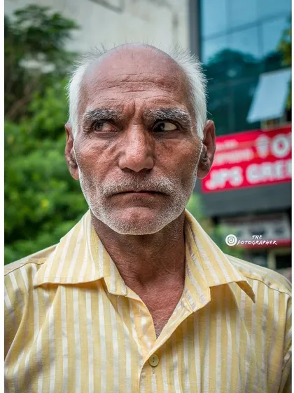 A slight turn of the head and a glance away can tell a different story. Here, the subject seems lost in thought, creating a more contemplative street portrait.