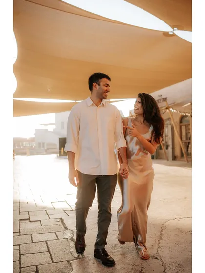 A candid walking shot through the shaded alleyways of Old Dubai. The natural canopy and warm light create a beautiful, romantic atmosphere for this pre-wedding photo.