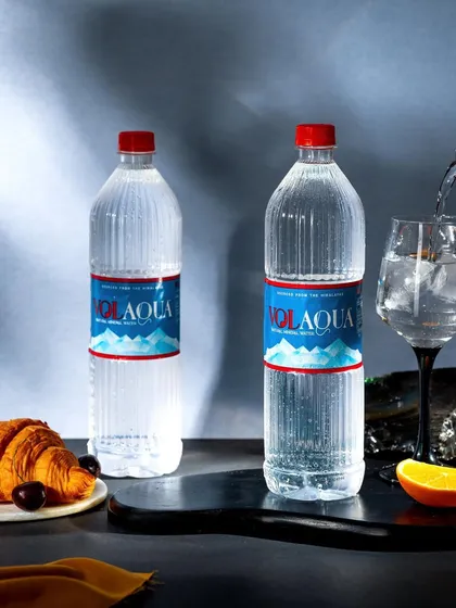 A clean and crisp shot of Volaqua mineral water being poured into a wine glass. The dark, contrasting background highlights the purity and clarity of the water, giving it a premium feel.