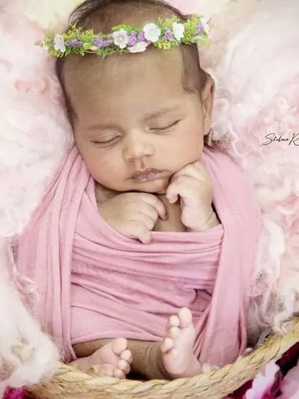 So serene and sweet, this little one looks like a tiny angel. The soft pink wrap and fluffy wool wings create a heavenly look for this newborn session.