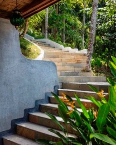 Stone steps wind through the lush gardens, connecting the different levels of the property in an organic way.