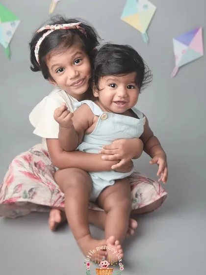A duplicate of image 67, highlighting the fun and loving relationship between these two siblings. The kites in the background add a playful touch.