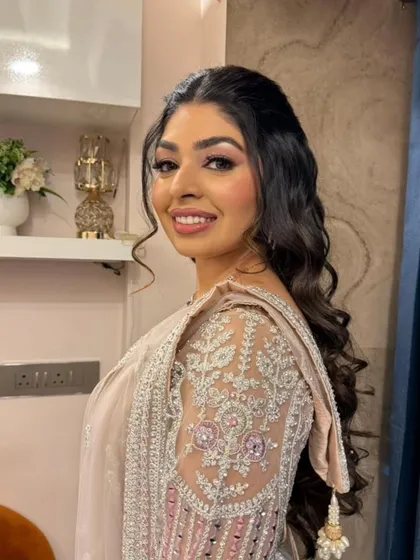 A modern and glamorous engagement look with soft, dramatic eyes and a camera-ready glow. The intricate details on her outfit are complemented by a timeless makeup style.