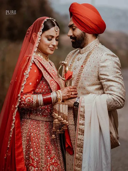 A beautiful portrait of the couple sharing a quiet moment. The bride's red dupatta and the groom's kirpan add a touch of traditional color and symbolism.