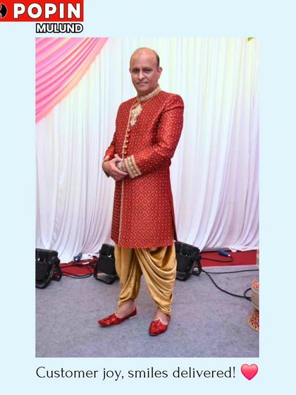 A client looking absolutely regal in a bright red embroidered sherwani paired with a golden dhoti. This is a powerful, traditional look, perfect for a groom on his wedding day.