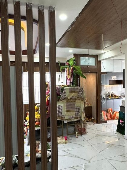 A view from the entrance of a newly completed home, showing a wooden partition that offers a glimpse into the living and kitchen areas. This design element creates a sense of separation while maintaining an open and connected feel.