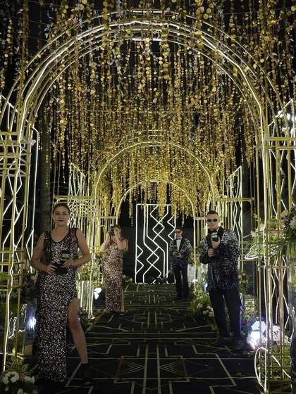 Creating a celebrity experience with a paparazzi-style entrance. This setup for a sangeet night makes the couple and their guests feel like stars walking the red carpet.