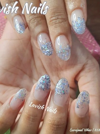 A beautiful chunky silver glitter fade on sheer, natural-looking almond nails.